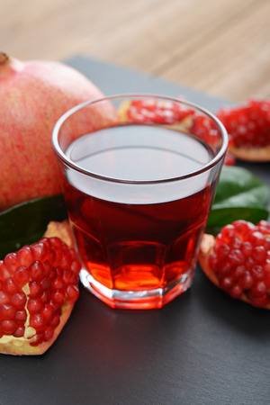 Pomegranate juice in glass and fresh fruits  on slate backgroundの写真素材