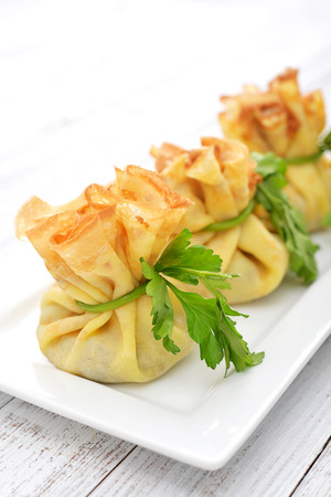 Bags of pancakes stuffed with mushrooms on white plate closeupの写真素材