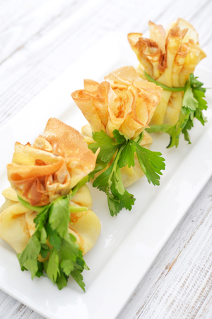 Bags of pancakes stuffed with mushrooms on white plate closeupの写真素材