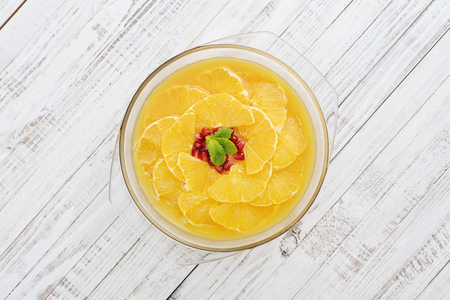 Pie with orange slices and pomegranate in jelly on wooden background closeupの写真素材