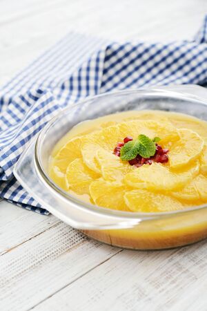 Pie with orange slices and pomegranate in jelly on wooden background closeupの写真素材
