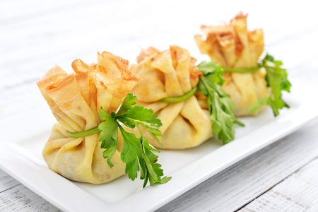 Bags of pancakes stuffed with mushrooms on white plate closeupの写真素材