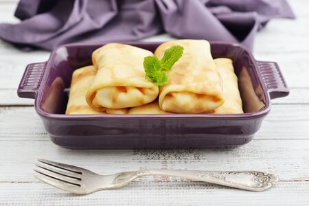 Stack of stuffed pancakes in baking mould on wooden backgroundの写真素材