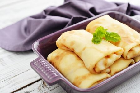 Stack of stuffed pancakes in baking mould on wooden backgroundの写真素材