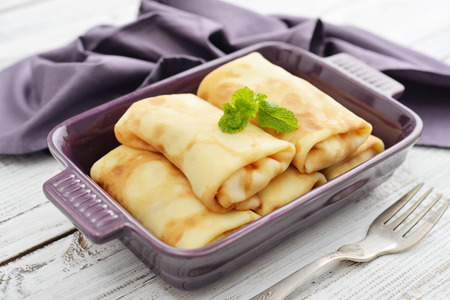 Stack of stuffed pancakes in baking mould on wooden backgroundの写真素材