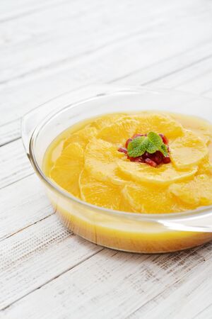 Pie with orange slices and pomegranate in jelly on wooden background closeupの写真素材
