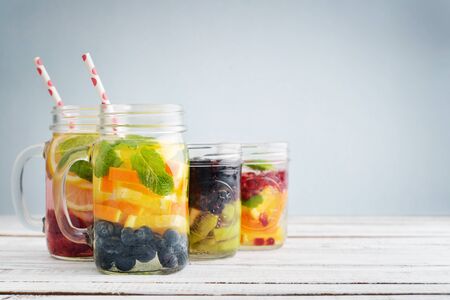 Detox drinks with fresh fruits and berries in glass jars on wooden backgroundの写真素材