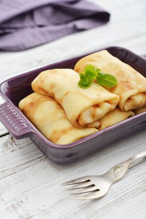 Stack of stuffed pancakes in baking mould on wooden backgroundの写真素材