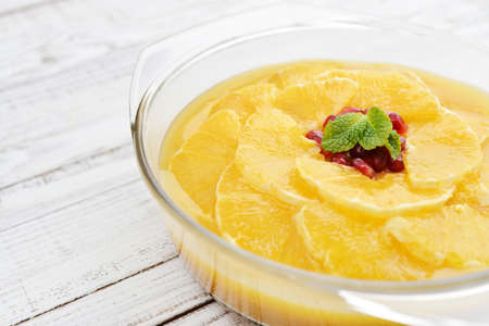 Pie with orange slices and pomegranate in jelly on wooden background closeupの写真素材