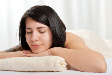 Beautiful young woman relaxing in spa after massageの写真素材