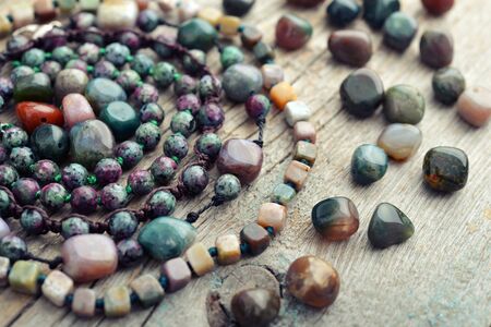 Beautiful semiprecious stone beads on wooden background closeupの写真素材