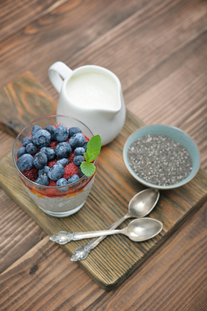 Pudding with chia seeds, yogurt and fresh berries in glass on wooden backgroundの写真素材