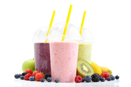 Fruit smoothies in plastic cups with blueberry, strawberry, kiwi, blackberry, raspberry and banana isolated on white background. Take away drinks concept.の写真素材