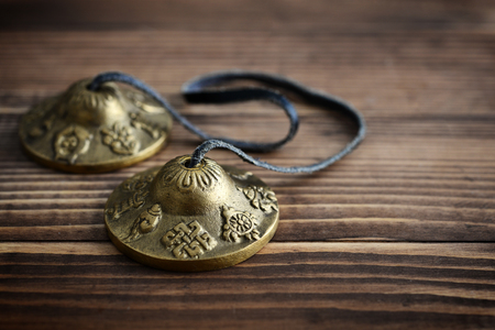 Tibetan Ting Sha Ceremonial Bells on wooden background closeupの写真素材