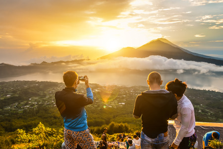 BALI, INDONESIA: Group of young people watch the dawn on top of the Batur volcano in Bali, Indonesia.の写真素材