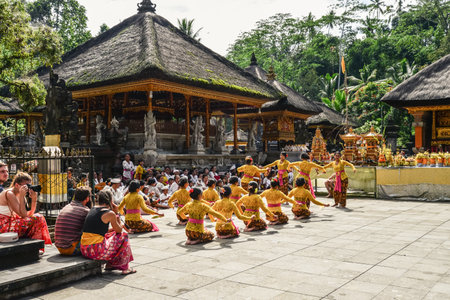 BALI, INDONESIA - MARCH 17, 2019: Balinese women in traditional costumes dance on territory of Holy Spring Water Temple (Pura Tirta Empul) on Bali, Indonesia.のeditorial素材