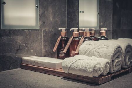 Stack of towels  in the bathroom with liquid soap dispenser  and tooth brushes  closeupの写真素材