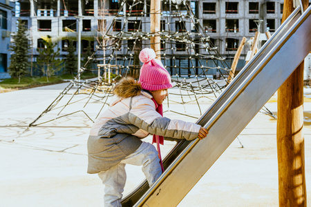 girl playing educational games on playground in winter. High quality photoの写真素材