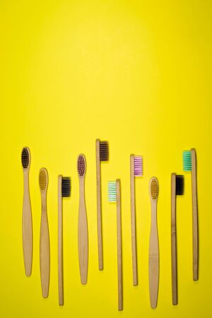 Bright bamboo eco toothbrushes on yellow background.の写真素材