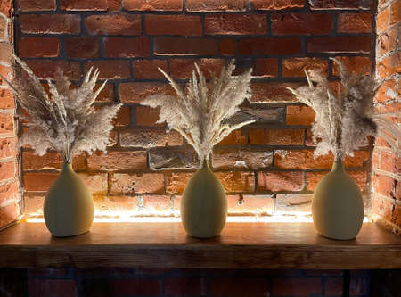 Bouquet of dry grass in a vase on a brick wall backgroundの写真素材