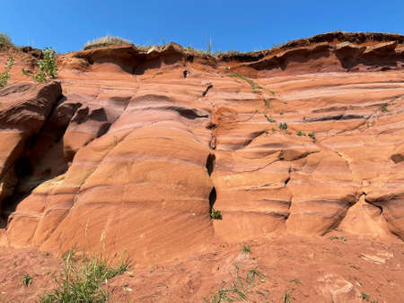 Uneven rough wall of red rock, part of the canyon in Kukmor, Tatarstan, Russiaの写真素材