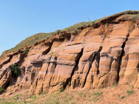 Uneven rough wall of red rock, part of the canyon in Kukmor, Tatarstan, Russiaの写真素材