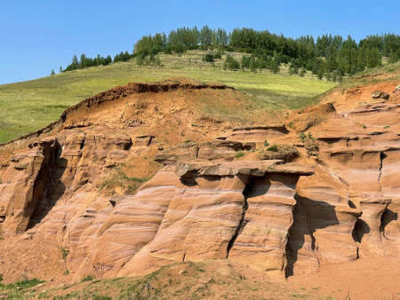 Uneven rough wall of red rock, part of the canyon in Kukmor, Tatarstan, Russiaの写真素材