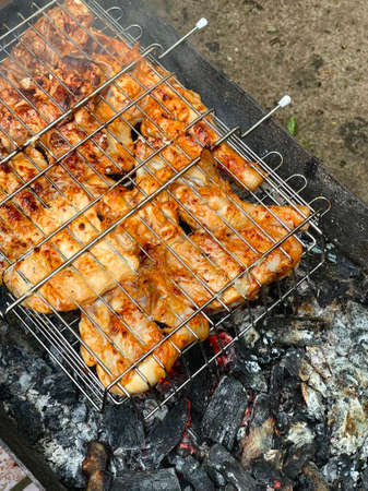 Grilled chicken on a grill with coalsの写真素材