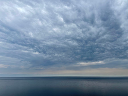 Heavy gray clouds over Lake Baikal, gloomy rainy day, foggy haze over the waterの写真素材