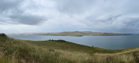 View of Lake Baikal in the early morning, foggy haze over the water. Gloomy harsh landscape.の写真素材