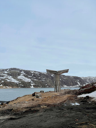 Whale tail wooden installation on the shore of the Barents Sea in spring day, Teriberka, Russiaの写真素材