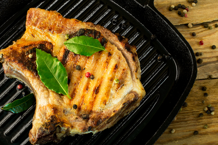 fried meat with green laurel leaves and pepper grains closeupの写真素材