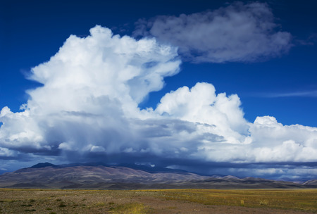 Beautiful cloud forms over the steppe prairie landscape with mountains in the background. Siberian Altai Mountains, Russiaの写真素材