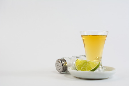 Tequila shot with lime and salt on white background. Gold Mexican tequila. Tequilaの写真素材