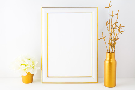 Frame mockup with ivory hydrangea in the golden flower pot. Poster white frame mockup. Empty white frame mockup for presentation artwork.の写真素材