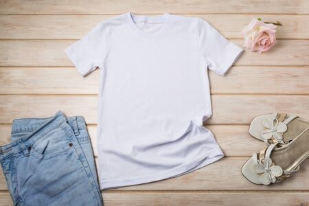 White womenâs cotton T-shirt mockup with pink roses, blue jeans and open toe sandals. Design t shirt template, tee print presentation mock upの写真素材
