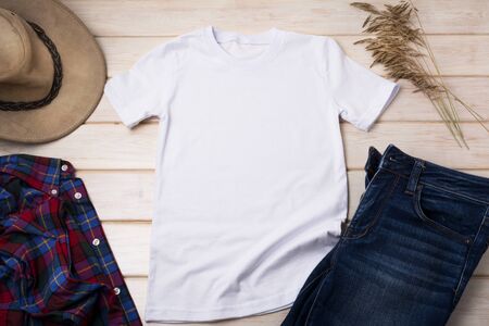 White menâs cotton T-shirt mockup with checkered tartan plaid shirt, dry grass and cowboy hat. Design t shirt template, tee print presentation mock upの写真素材