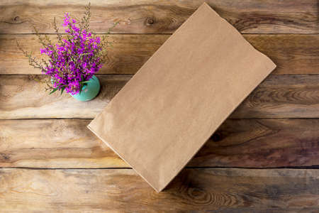 Brown paper shopping bag mockup with purple wildflowers. Kraft recycled grocery shopping bag mock up for branding presentation.の写真素材