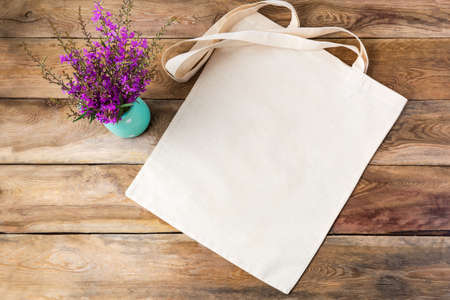 Canvas tote bag mockup with purple wildflowers. Rustic linen shopper bag mock up for branding presentationの写真素材