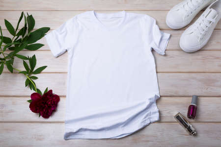 White women's cotton T-shirt mockup with sport shoes, burgundy peony, nail polish and lipstick....