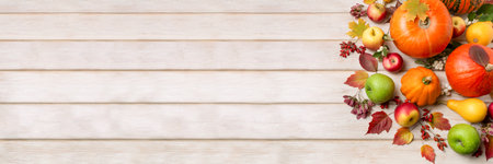 Banner for social media with fall pumpkin, autumn leaves, red, green apples and berries on the wooden backgroundの写真素材