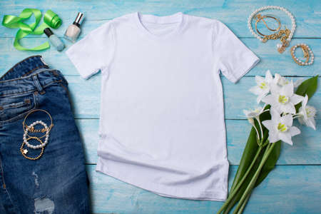 White womens cotton T-shirt mockup with white lilies, bijouterie and nail polish. Design t shirt template, tee print presentation mock upの写真素材