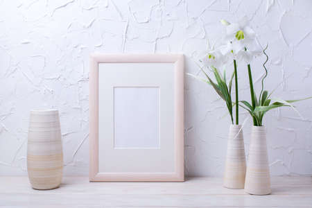 Wooden frame mockup with tender lily bouquet and striped vases. Empty frame mockup for presentation...