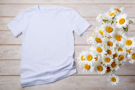White womens cotton T-shirt mockup with wild chamomile. Design t shirt template, tee print presentation mock upの写真素材