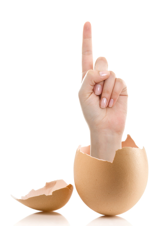 Hand with broken egg isolated on white backround. Woman index finger isolated on white backgroundの写真素材