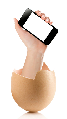 Hand with broken egg isolated on white backround. Hand of young man holding smart phone white screen isolated on white background with clipping pathの写真素材