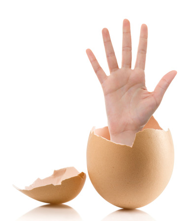 Hand with broken egg isolated on white backroundの写真素材
