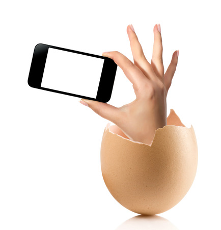 Hand with broken egg isolated on white backround. Hand of young man holding smart phone white screen isolated on white background with clipping pathの写真素材