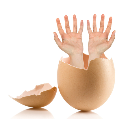 Hand with broken egg isolated on white backroundの写真素材