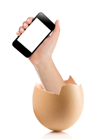 Hand with broken egg isolated on white backround. Hand of young man holding smart phone white screen isolated on white background with clipping pathの写真素材